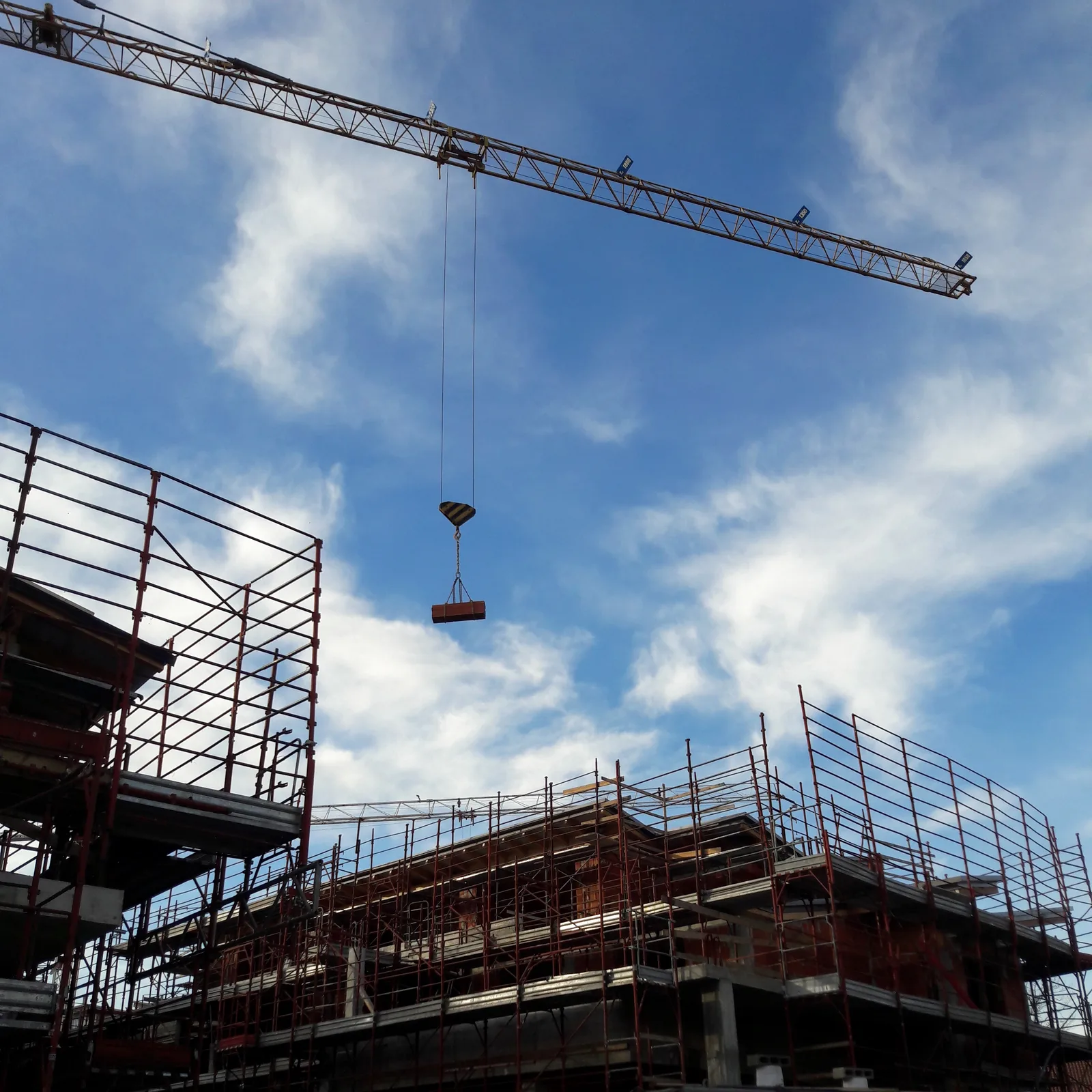 Rohbaustelle mit Baukran und Gerüst
